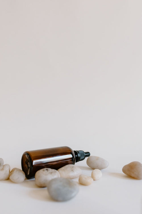 Aromatherapy diffuser and essential oils with stones on a white surface