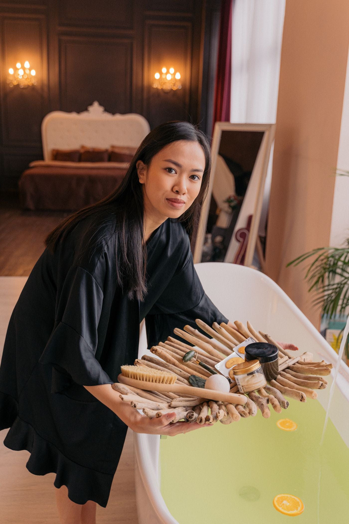 Person in a robe holding bathing essentials