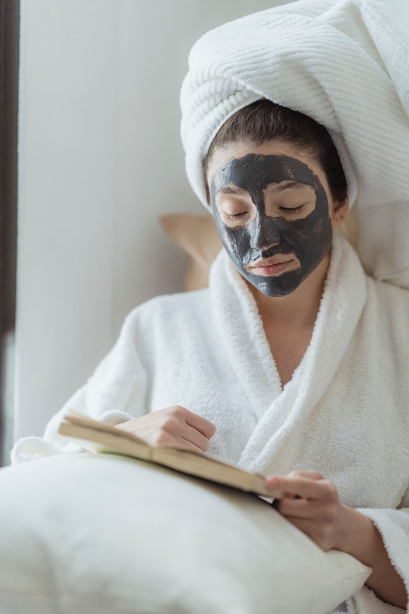 Woman relaxing with a face mask while reading